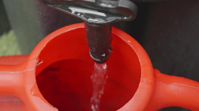 Water butt nozzle filling watering can close up