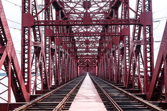 Pabna, Rajshahi Division, Bangladesh - 17 August 2025: View of the Hardinge Bridge, a historic red steel truss railway bridge spanning the Padma River with intricate metal girders and tracks.
