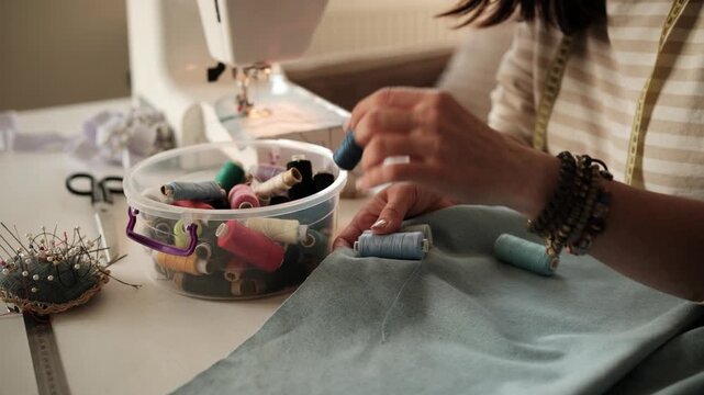 Seamstress Matches Thread To Fabric Color With Hands Up Close