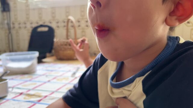Medium shot video of a boy eating bread with sobrasada with family