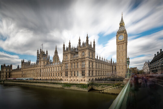 London, United Kingdom - 26 April 2023: View of the Palace of Westminster and Big Ben with long exposure clouds moving across the sky above the River Thames.