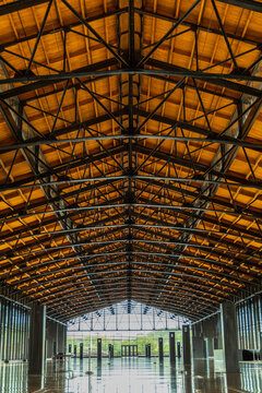 Richmond, Virginia, United States - 08 August 2024: View of the interior of a spacious industrial building featuring a high vaulted ceiling with exposed steel trusses and wooden beams.