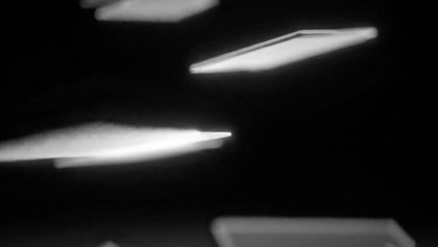 Abstract glowing geometric shapes in motion against a dark background.