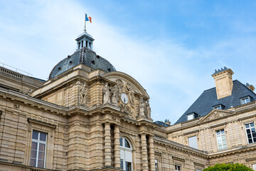 Fototapeta premium looking up at palace in the jardin du Luxembourg in Paris city centre public park with green trees and clear blue sunny skies overhead in summer