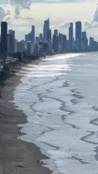 Burleigh Heads drone flight along the beach with the city skyline beyond, Gold Coast, Queensland Australia - vertical video