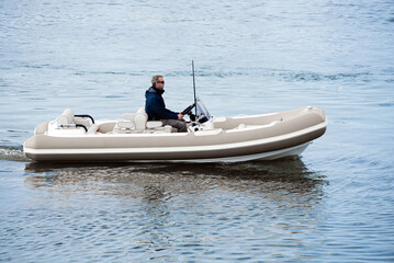 Caucasian Male Superyacht Deckhand doing tender driving on turbo jet boat in port © lupiphoto