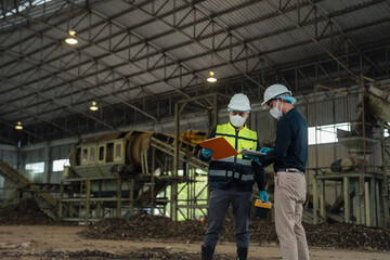 Fototapeta premium environmental engineers inspecting organic waste pile in waste-to-energy power plant.