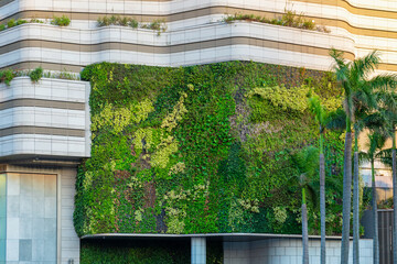 Modern building facade with green living wall and integrated landscaping in Hong Kong city....