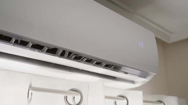 Close-up of air conditioner temperature being adjusted to 19 degrees Celsius to cool the room during extreme summer heat, representing indoor climate control and heat relief