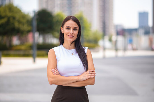 Professional businesswoman smiling with arms crossed in city