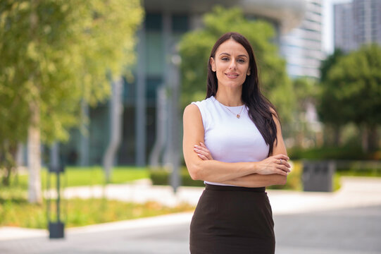 Confident business woman standing outdoors with arms crossed