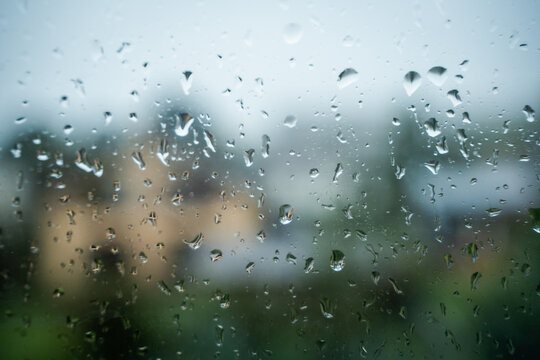 View of raindrops on a glass window pane with a blurred background in Riga, Latvia.