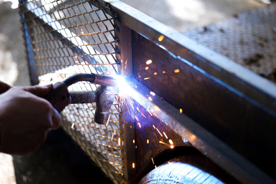 Welding metal fabrication worker spark construction workshop industrial closeup safety