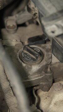 A close up of a car engine oil filler cap.