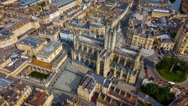 Aerial view of Bath Abbey and the Roman Baths surrounded by historic Georgian architecture and stone rooftops in the city centre of Bath, England, United Kingdom.