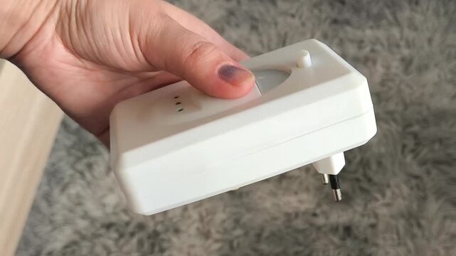 Woman holding ultrasonic pest control device, protection from cockroaches, spiders and unwanted insects in the home.