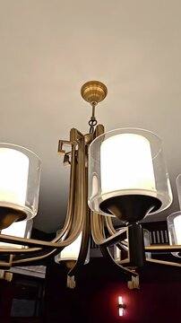 Modern style chandelier hanging from ceiling with illuminated lamps, Decorative Electric Bulbs, Room Interior Decoration, Rotating Shot, Slow Motion