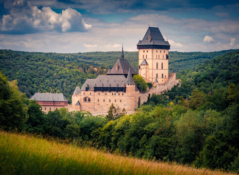 Dramatic morning view of Gothic Karlstejn castle, Beroun District, Central Bohemian Region, Czech Republic, Europe. Exciting summer landscape of old palace among green forest.