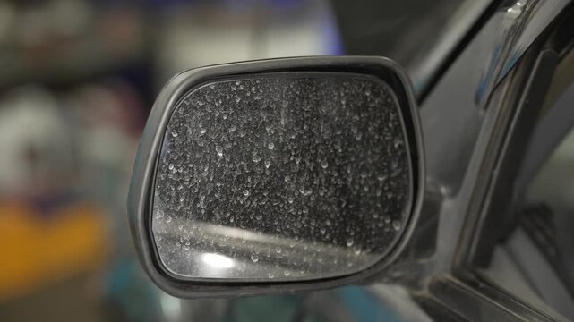 A close up of a dirty car side wing mirror.