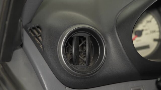 A close up of a round car dashboard air vent.