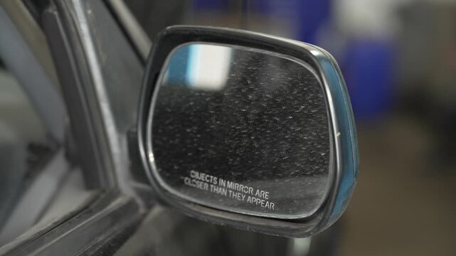 A close up of a dusty passenger side wing mirror.