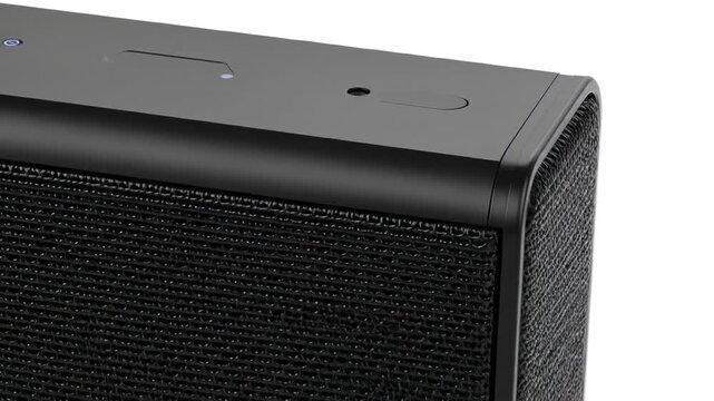 Black speaker device closeup with white background.