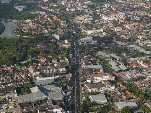 Aerial view of the Statue of Dewa Ruci surrounded by dense urban development, busy roads, and lush greenery in Kecamatan Kuta, Bali, Indonesia.