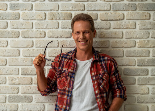 Smiling Man Holding Sunglasses.