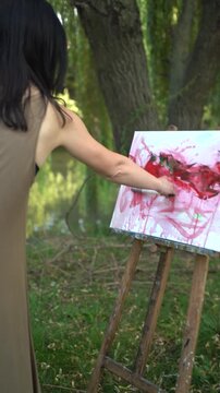 Woman painting outdoors on a canvas and easel and artist palette