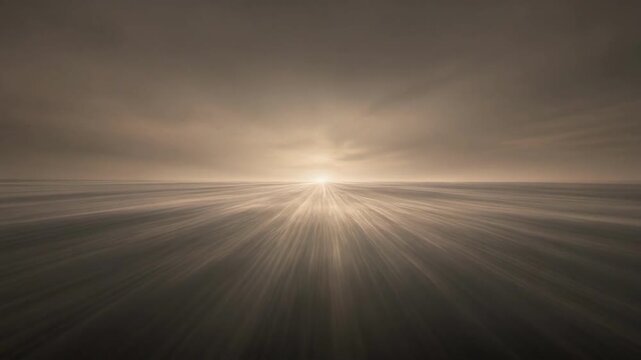 Sunrise or sunset over a vast, blurred landscape with radiating light rays