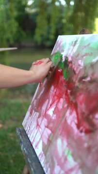 Woman painting outdoors on a canvas and easel and artist palette