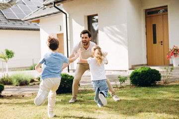 Obraz premium Happy father playing with children in garden at home