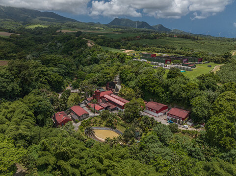 Aerial view of Distillerie J.M nestled in lush tropical vegetation with mountains in the background in Martinique.