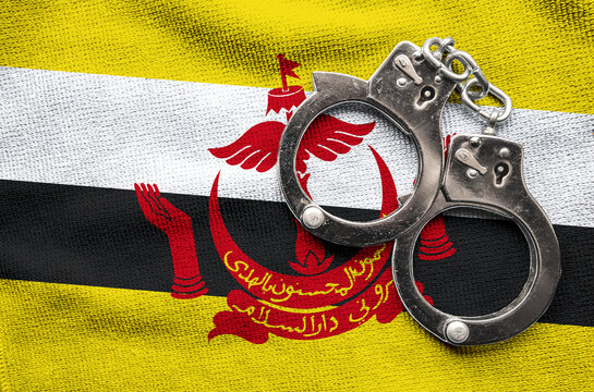 Flag of Brunei and police handcuffs. Crime and offenses in country Concept
