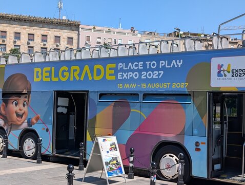 02 August 2026, Belgrade, Serbia: Expo 2027 advertising covers a tour bus parked on a Belgrade boulevard during preparations for the international specialized exhibition. 