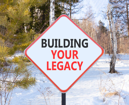 Building your legacy words symbol. Concept words Building your legacy on beautiful white road sign. Beautiful winter forest background. Business building your legacy concept. Copy space.