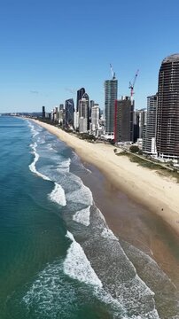 Aerial drone view over Surfers Paradise beach, esplanade and apartment towers, Gold Coast, Queensland Australia - vertical video