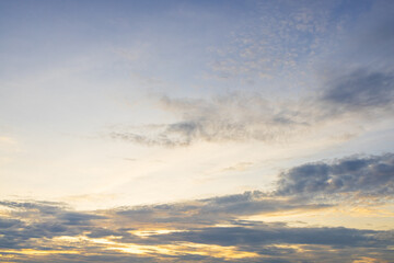 Obraz premium Beautiful Sunset Sky with Colorful Clouds and Golden Light,A stunning view of the evening sky filled with dramatic clouds, illuminated by the warm golden and orange light of sunset blending into.