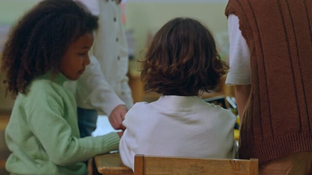 Child classroom learning teacher student education group school lesson diverse preschool activity around desk table with cooperation creative play calm indoor room soft focus study together