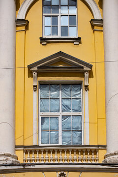 Ornate yellow facade window covered with protective plastic sheeting