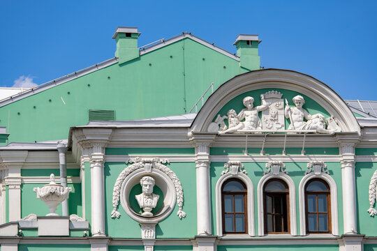 Ornate green facade with cherub relief and bust medallion