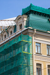Historic building facade and roof under renovation with scaffolding © Mariia