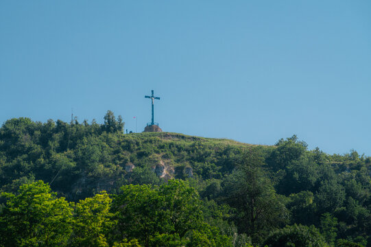 Croix religieuse au sommet d'une colline bois&eacute;e