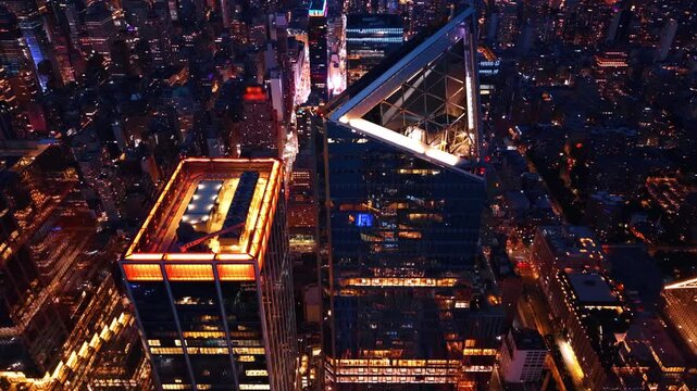 Overhead view of Hudson Yards skyscrapers at night, New York. High angle look at triangular observation deck roof and lit architecture in financial district.