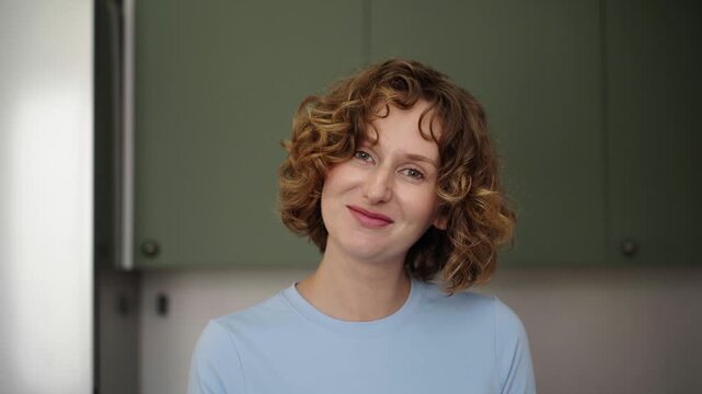 Woman bakes layered sponge cake in sunlit cozy kitchen, 25 fps