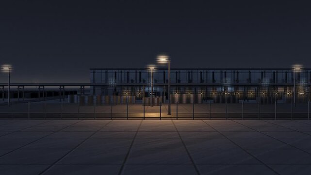Modern data center building behind security fence at night