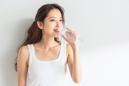 ペットボトルの水を飲んで水分補給する女性

