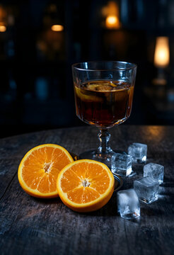 Craft cocktail culture and mixology, old fashioned drink with orange slices and ice cubes on a dark wooden bar