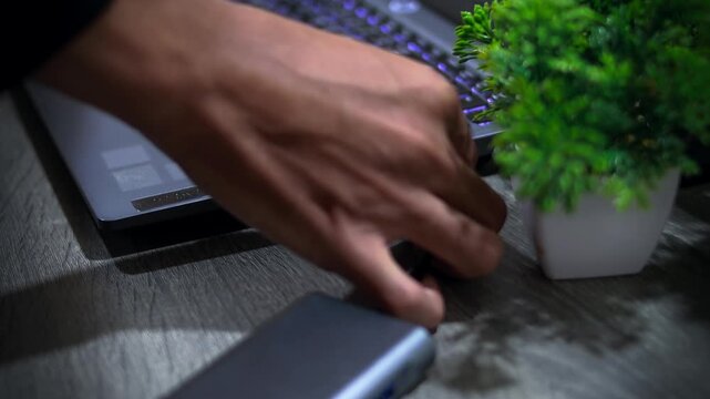 Close up businessman connecting USB data cable to laptop for remote work and home office concept.