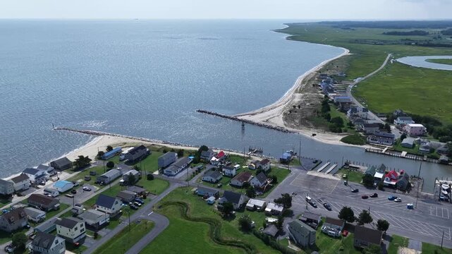 Small fishing community on Delaware coastline at Bowers Beach with marina and inlet waterway with natural wetlands